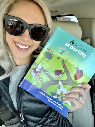 selfie with Katie and her JA Our City® volunteer guidebook